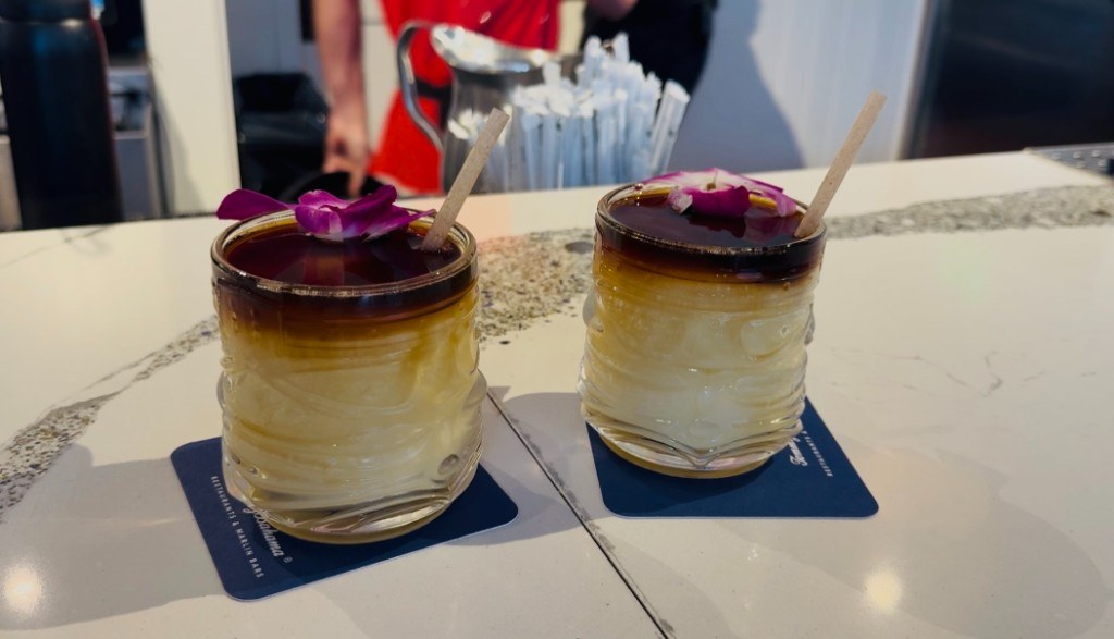 Two Mai Tai cocktails on Tommy Bahama coasters on a marble bar counter South Florida